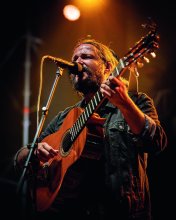 Songwriter Nano Stern mit Gitarre vor dem Mikrofon