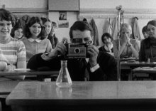 Ein mann, der durch eine Kamera schaut. Das bild ist schwarz weiß, und stammt aus einer Aufnahme aus 1968