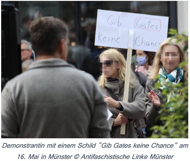 Eine Frau hält auf einer Demonstration ein Schild mit der Aufschrift Gib Gates keine Chance hoch