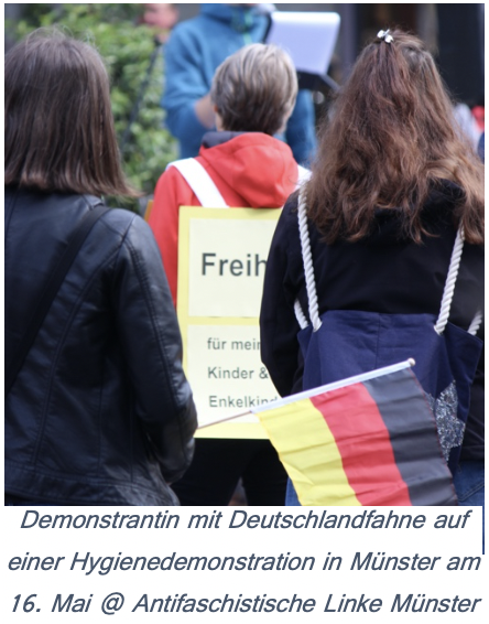 Eine Frau hält auf einer Demonstration eine Deutschlandfahne hoch