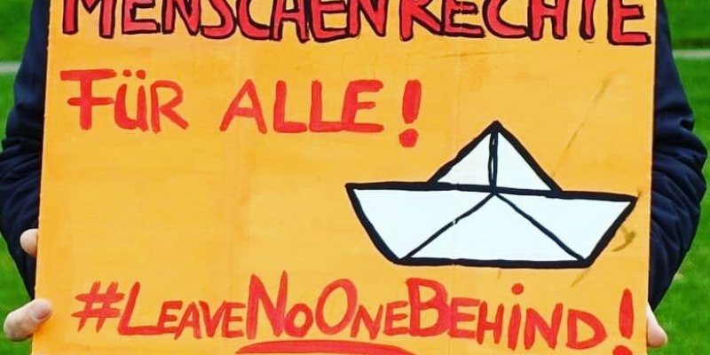 Mensch hält Schild: "Menschenrechte für Alle! #LeaveNoOneBehing!"