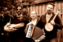 Das Trio Overall Brigade, zwei Männer, eine Frau, mit Instrumenten