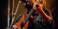 Songwriter Nano Stern mit Gitarre vor dem Mikrofon