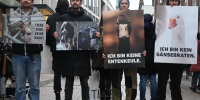 4 Aktivis halten Plakate mit veganen Botschaften.